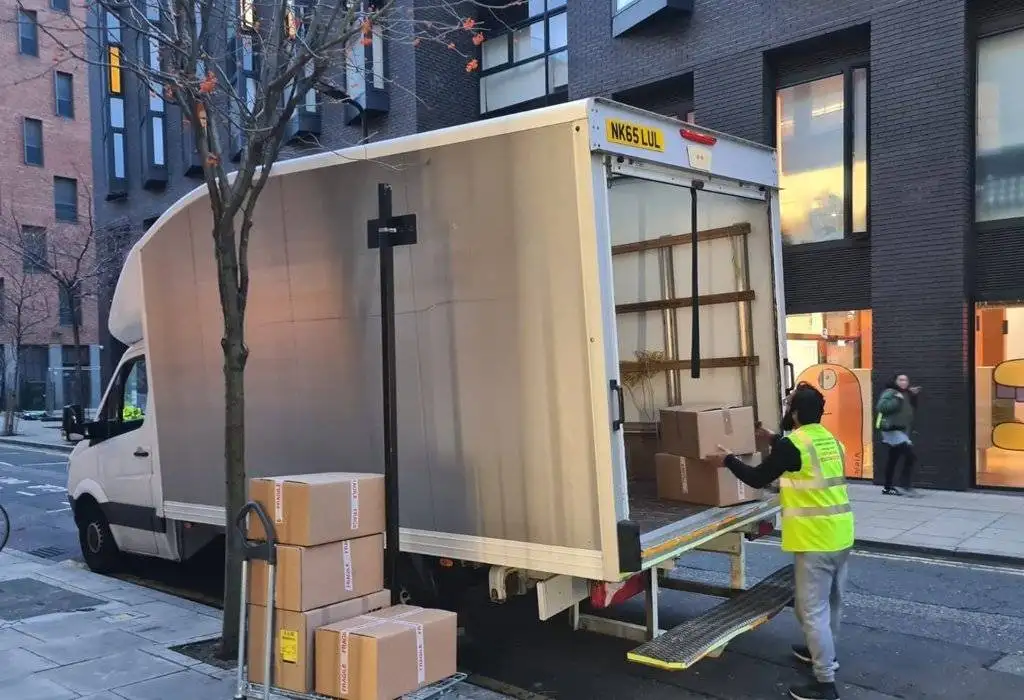 there is a man loading packed boxes in the truck