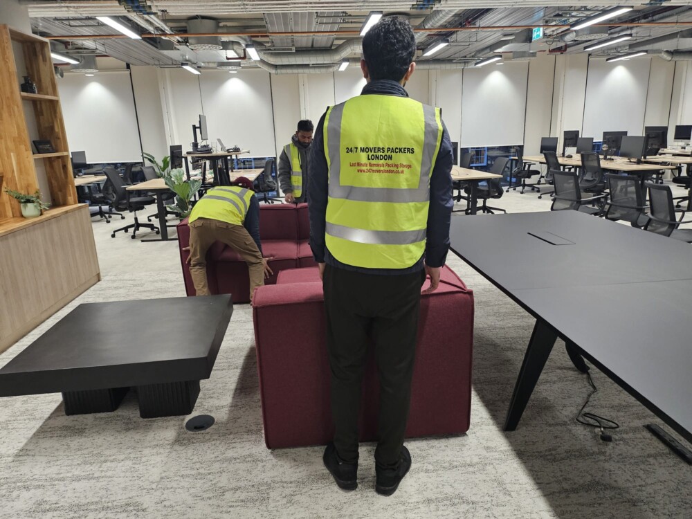 Three persons of a moving company are transferring stuff from a large office.