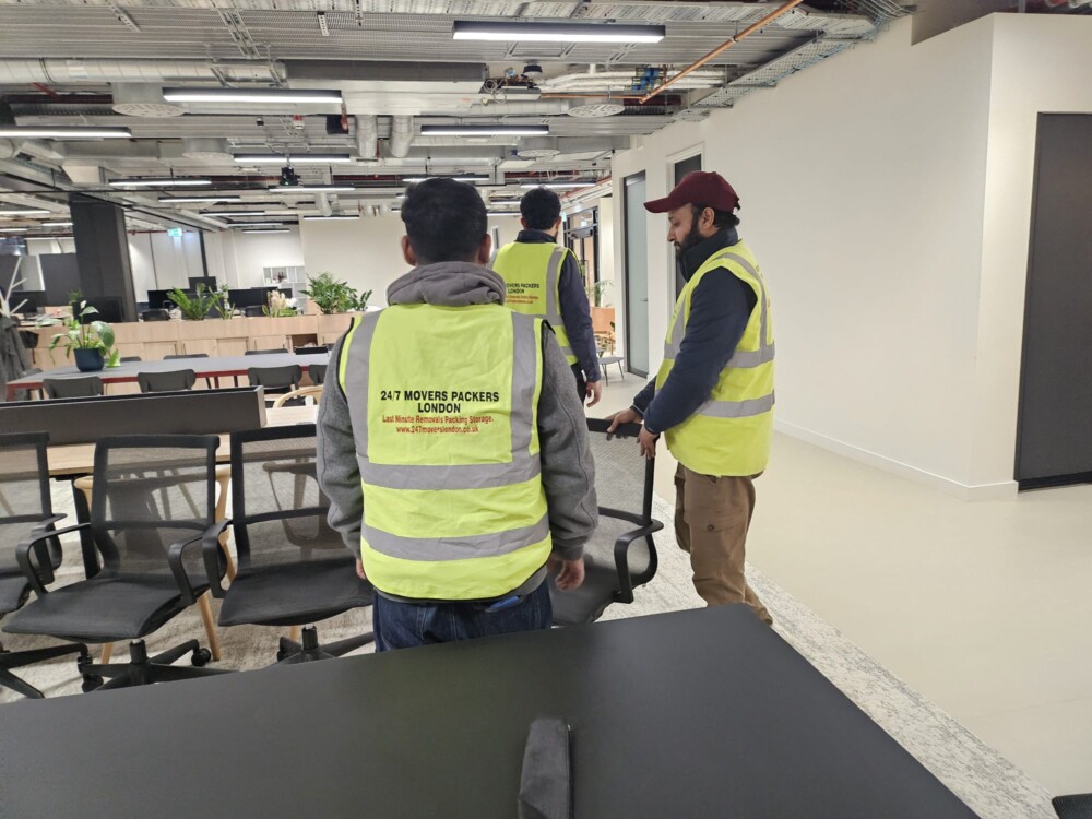Three persons of a moving company are transferring stuff from a large office.